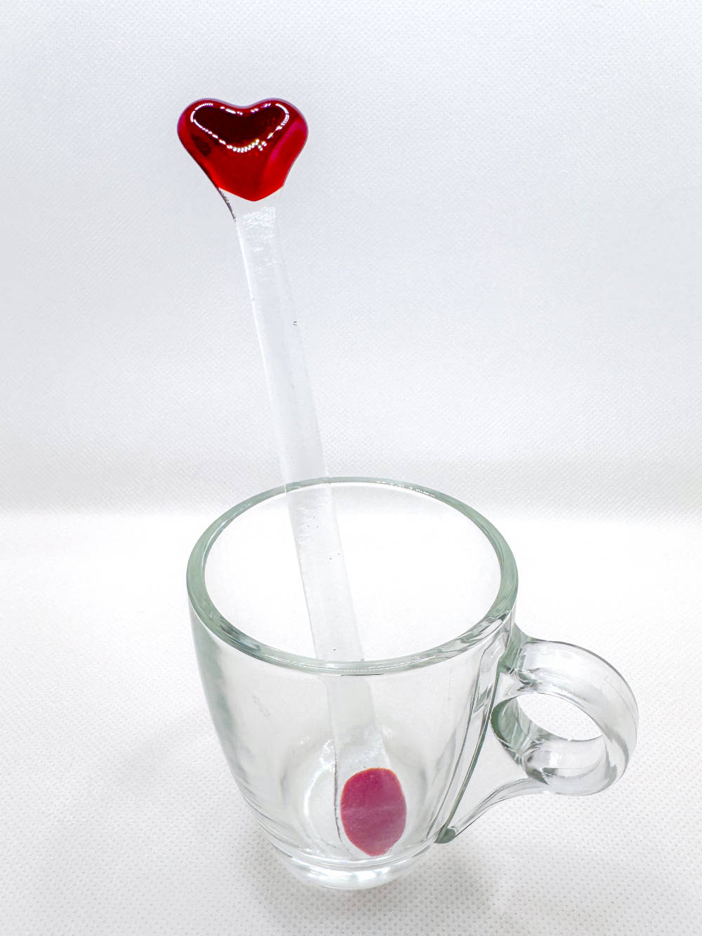 red and clear glass stir stick in a glass cup
